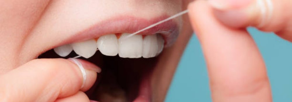 istockphoto-858591060-612×612 Oral hygiene and health care. Smiling women use dental floss white healthy teeth.